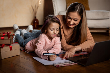 Portrait of happy woman and daughter writing letter to Santa