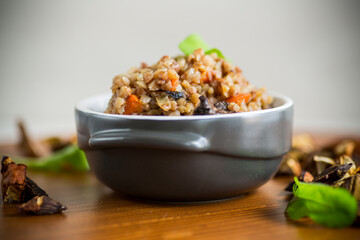 boiled buckwheat with vegetables and dried forest mushrooms in a ceramic mold