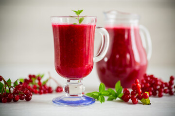 freshly squeezed thick natural juice with pulp from ripe red viburnum in a decanter