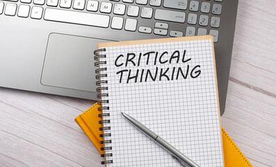 CRITICAL THINKING text written on a notebook on the laptop
