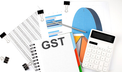 Text GST on a notebook on the diagram and charts with calculator and pen