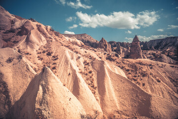 Fototapeta na wymiar Landscape with houses in Cappadocia mountains under blue sky, Turkey