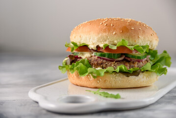 Vegetarian burger with bean patty on grey concrete background