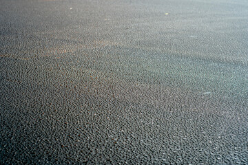 Dark background with large drops of water on fresh asphalt. Road surface wet from rain. Black sad backdrop