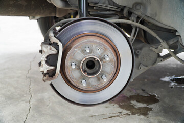 Disc brake of the vehicle for repair,Seal a leaking car tire.Car brake repairing in garage. - obrazy, fototapety, plakaty