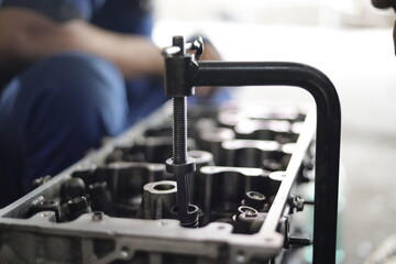 the hand of a mechanic is installing the valve seal of an overhauled car engine