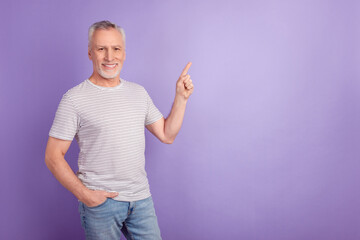 Photo of mature man indicate finger empty space advertise choice direct isolated over violet color background