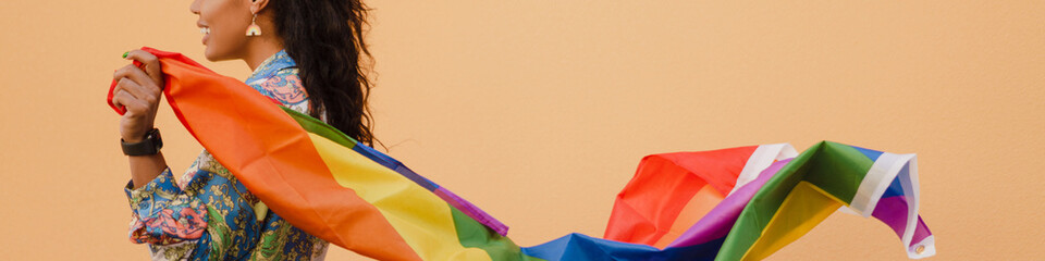 Fototapeta premium Black woman with rainbow flag smiling and looking aside