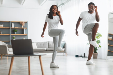 Obraz premium Young black couple doing twist knee to elbow exercise