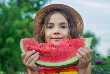 The child eats watermelon in the summer. Selective focus.