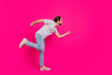 Full length profile side photo of young cheerful man run discount empty space isolated over magenta color background