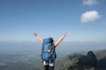 A trekker extends his arms on top of the mountain.