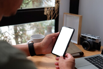 Close up view of businessman holding mock up smart phone with blank screen..