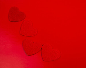 Red felt hearts love decor on the red background