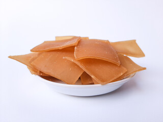 Raw Kerupuk terigu, or flour crackers, before fried. Square shape. A complement for Indonesian food, or as a snack. Placed inside a white plate, isolated in white background