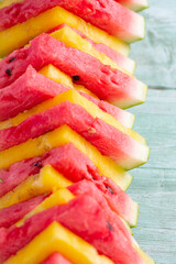 yellow and red water melon on turquoise surface