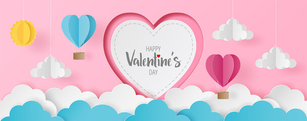 Paper cut of Happy Valentine's Day text on white heart with heart hot air balloons, sun and cloud on light pink background for greeting card, banner, headers website