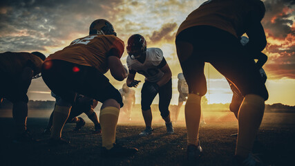 American Football Field Two Teams Stand Opposite Each Other, Ready to Start the Game. Professional Athletes Preparing to Compete for the Ball, Tackle and Fight for Victory. Dramatic Golden Hour Shot