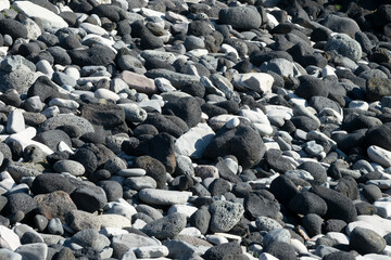 Close up of black lava rocks and pebbles on a beach in Iceland