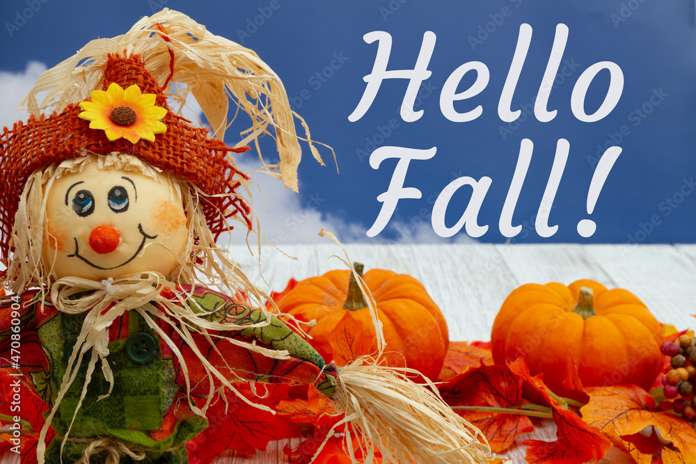 Wall mural Hello Fall greeting with fall leaves, scarecrow, and pumpkins with sky - Wall murals
