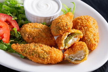 Jalapeno Poppers with sour cream in a white plate - obrazy, fototapety, plakaty