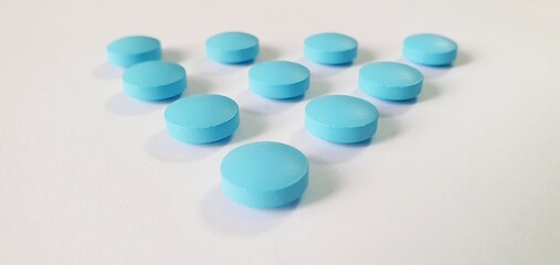 Blue tablets and vitamins without packaging on the table. Treatment pills. Useful vitamins for treatment.