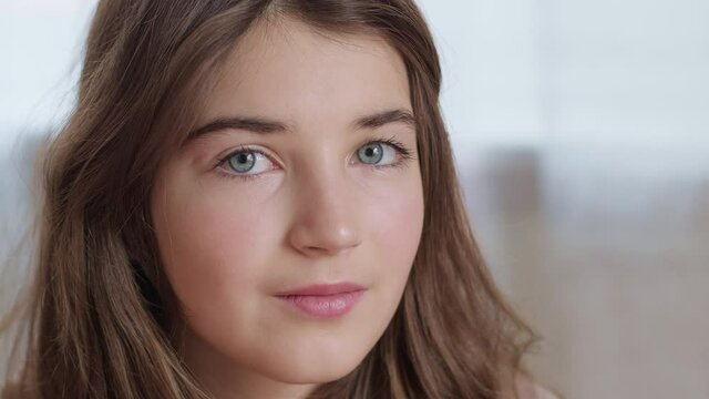 The face of a beautiful teenage girl looking at the camera. Close-up. Portrait of a smiling girl.