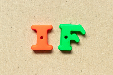 Plastic alphabet letter in word if on wood background