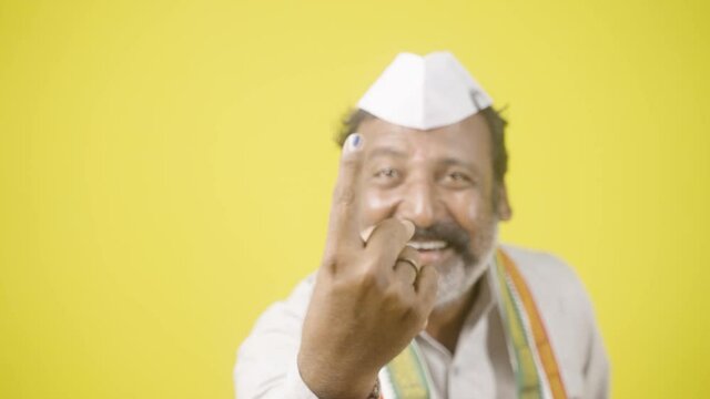 Happy smiling politician showing ink marked finger after voting in election polls - concept showing of Indian election and democractic system.