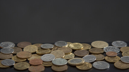 coins of different countries on a dark background. copy space