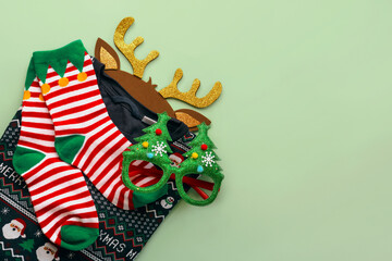 Fototapeta na wymiar Merry Christmas. Top view of christmas sweater with christmas socks,bright Christmas toy deer antlers and funny glasses.Christmas concept background