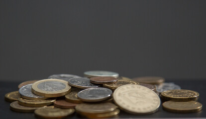 coins of different countries on a dark background. copy space