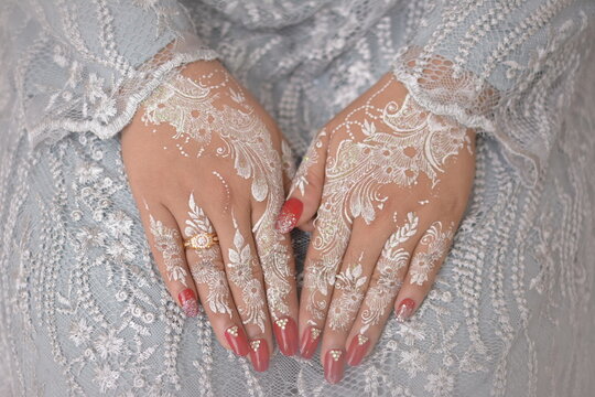 close-up of beautiful woman with henna tattoo on her hand. Beautiful Bridal Hands with henna and Wedding Rings.