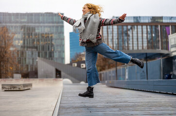 Happy young woman jumping in the city 
