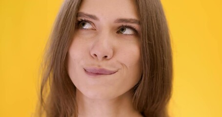 Sweet dreams. Close up of young dreamy lady imaging something interesting and biting her lips, anticipating pleasure