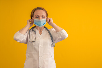 A woman doctor wears or removes a mask.