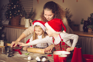 Mom and children are preparing cookies in the kitchen.