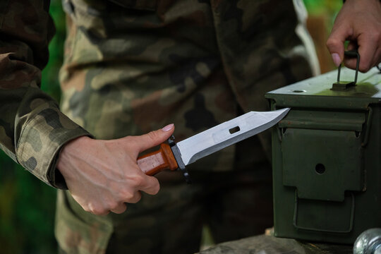 A soldier tries to break into a locked ammunition box. Close-up view.