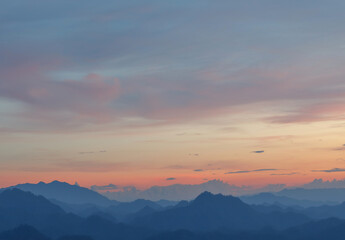 Fototapeta na wymiar Predawn clear sunset sky with mountain layers landscape and orange horizon and blue atmosphere.
