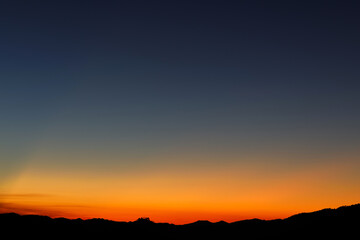 Heaven at early morning with copy space. Sunset, sunrise backdrop.Predawn clear sky with orange horizon and blue atmosphere. Smooth orange blue gradient of dawn sky.
