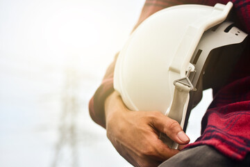 Obraz premium Technician holding white hat safety hard hat sunlight background