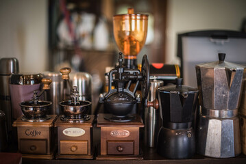 Fototapeta na wymiar A set of hand-cranked coffee grinders and a Moka coffee pot are displayed on the coffee counter.