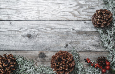 Rustic wooden background with fir branches and natural pine cones for christmas