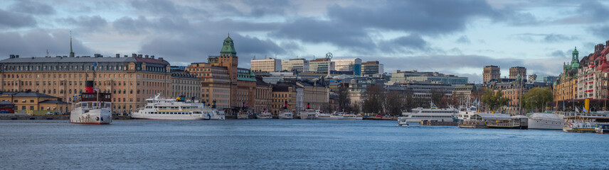 Panorama view over the bay Nybroviken a part of the bay Ladug&aring;rdsviken, commuting steam boats and hotels and office buildings at the pier Strandv&auml;gen, an color full day in Stockholm
