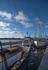 Old sailing, fishing and cargo boats at the pier Strandvägen in the bay Ladugårdsviken a color full autumn day in Stockholm