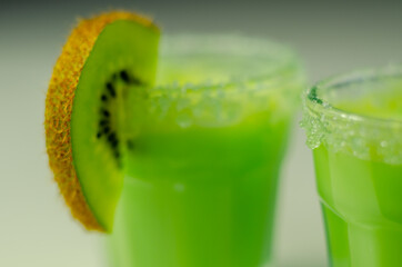 Fruit shot drink based on alcohol, liqueur and cream, decorated with green sugar crystals and a...