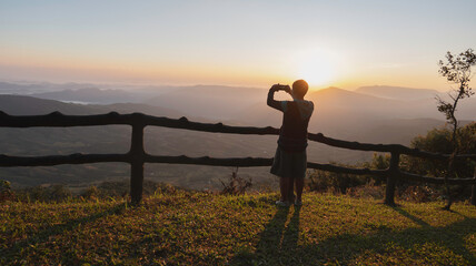 traveller use smartphone take photo at mountain at sunrise