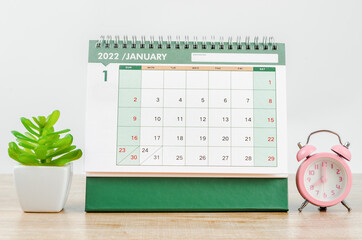 January 2022 desk calendar on wooden table.