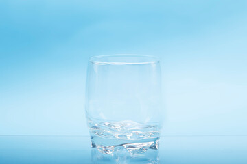 Transparent empty water glasses with blue background.