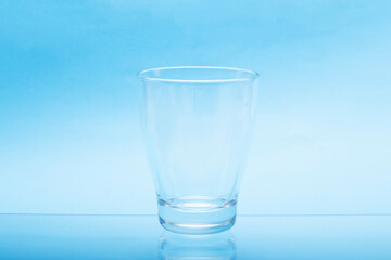 Transparent empty water glasses with blue background.